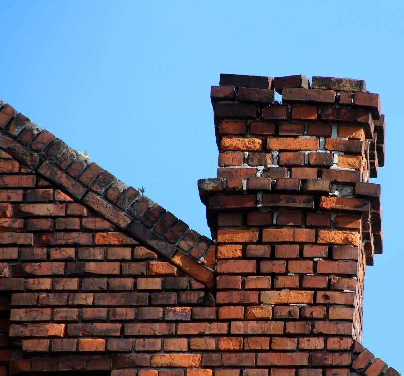Damaged chimney on an Cerritos home showing cracks and missing mortar